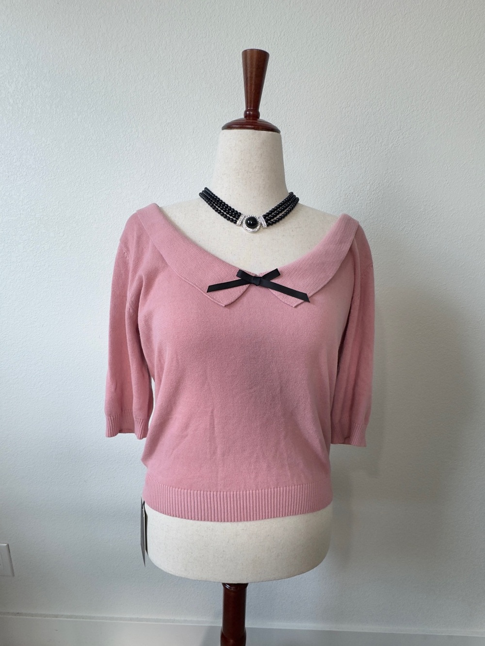 Collectif Babette Jumper - Off-the-Shoulder Pink Sweater with Black Bow Accent